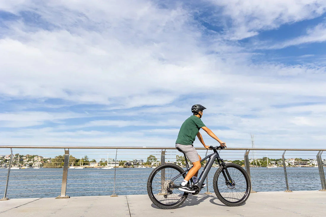 The right electric bike for me at Bicycle Centre. Male riding an ebike along the river. 
