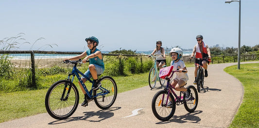 Shop bikes at Bicycle Centre Australia this Spring. Family of four bike riding along the coastline at the beach, on Hardtail mtb's, kids bikes and cruisers. Best Bike Shop Australia and near me.
